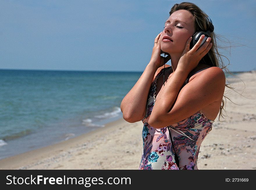 A lovely girl with the headphones listening to music. A lovely girl with the headphones listening to music