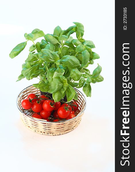 Cherry tomatoes and basil in a wicker basket