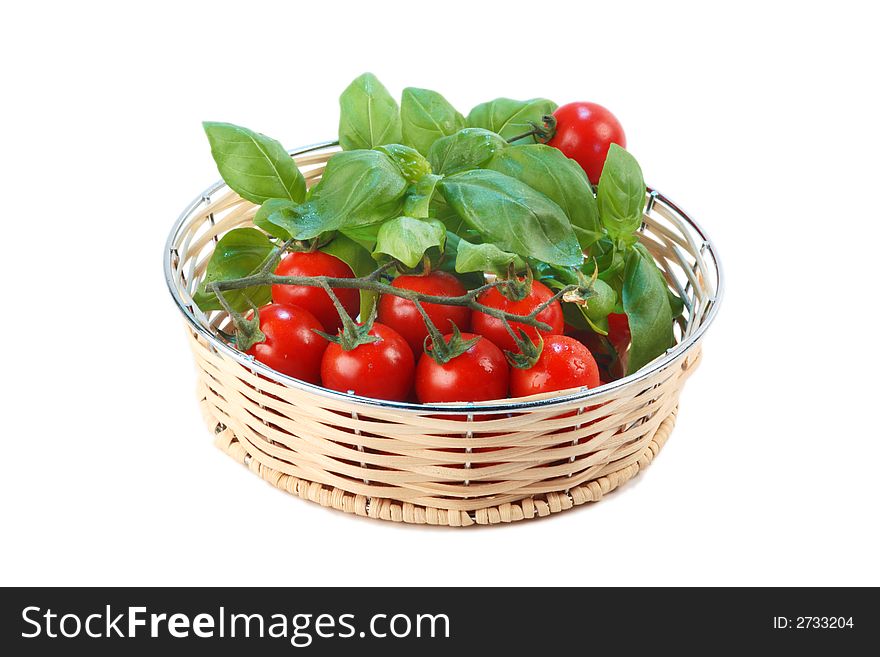 Cherry tomatoes and basil in a wicker basket