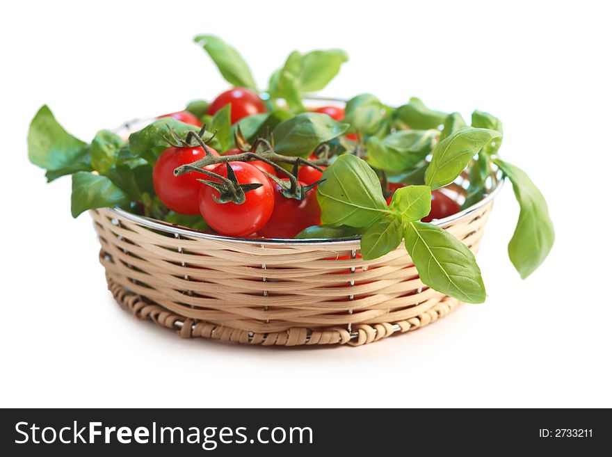 Cherry tomatoes and basil in a wicker basket