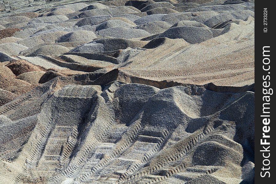 Warehouse of sand and gravel. Traces left by a tractor. Warehouse of sand and gravel. Traces left by a tractor