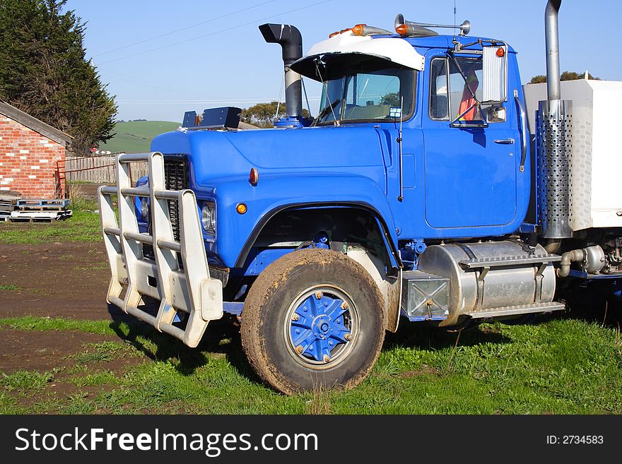Small blue truck parked on green grass. Small blue truck parked on green grass