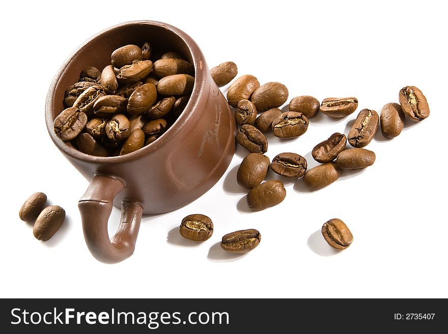 Coffee grains in small ceramic brown cup. Coffee grains in small ceramic brown cup
