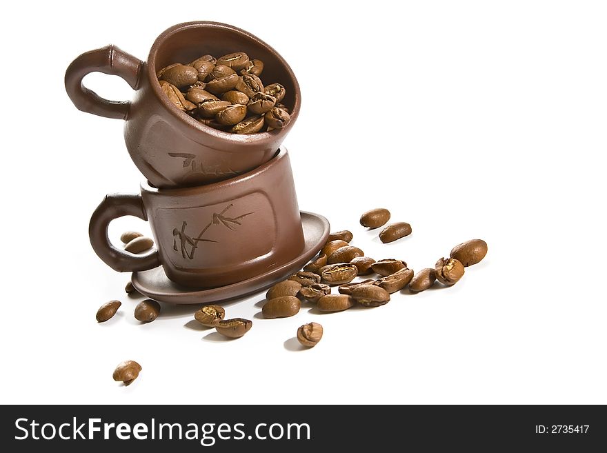 Coffee grains in small ceramic brown cup. Coffee grains in small ceramic brown cup