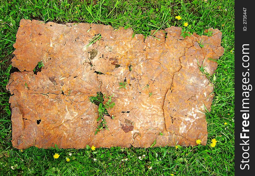 Sheet of rusty iron on a green grass