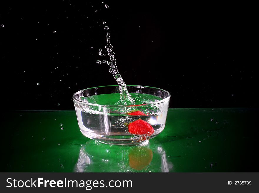 The fruits splash into glass of water. The fruits splash into glass of water