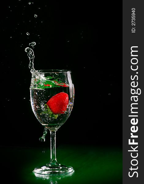 The fruits splash into glass of water. The fruits splash into glass of water