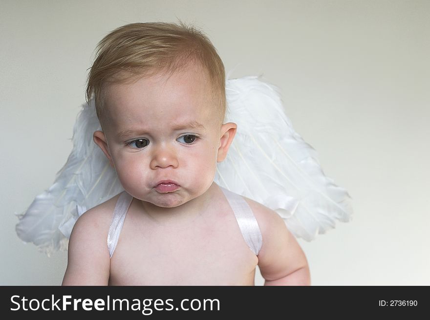 Image of an adorable toddler wearing angel wings. Image of an adorable toddler wearing angel wings