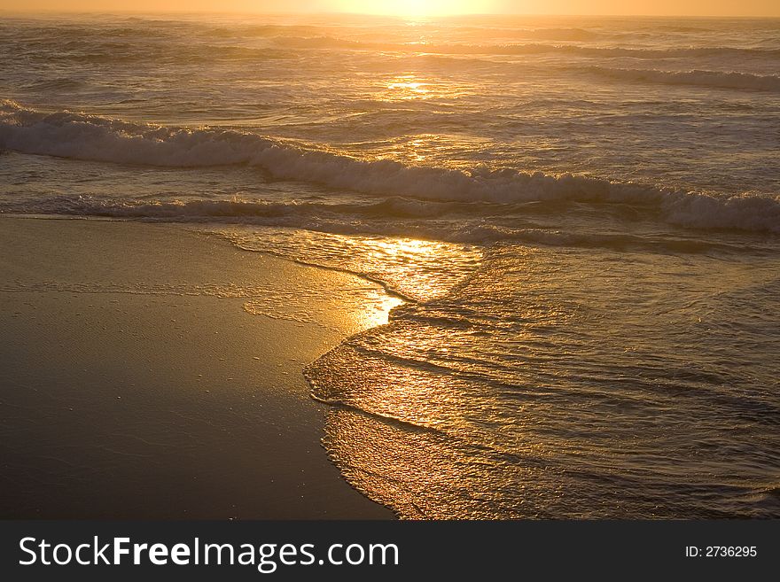 Yellow color sunrise over the sea including the waves on the shore. Yellow color sunrise over the sea including the waves on the shore.