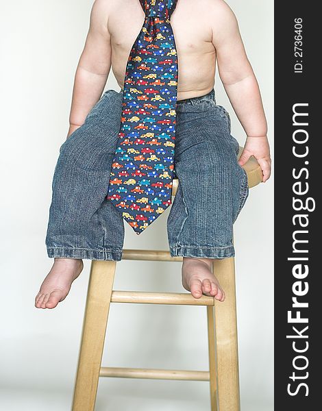 Image of cute toddler, only visible from the neck down, wearing jeans and a tie. Image of cute toddler, only visible from the neck down, wearing jeans and a tie