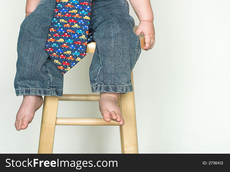 Image of toddler, only visible from the waist down, wearing jeans and a tie. Image of toddler, only visible from the waist down, wearing jeans and a tie