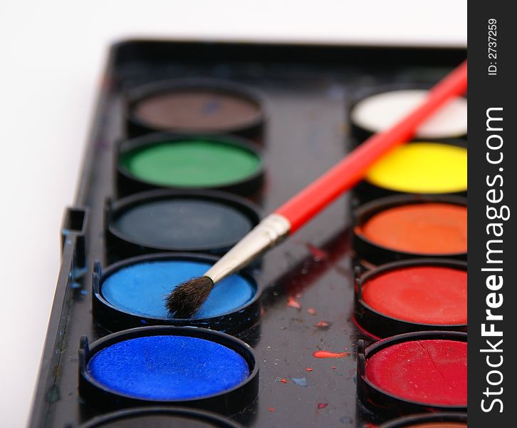 Closeup of a palette of watercolor paints with red brush. Closeup of a palette of watercolor paints with red brush.