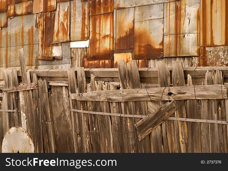 Old wooden fence against steel wall background. Old wooden fence against steel wall background