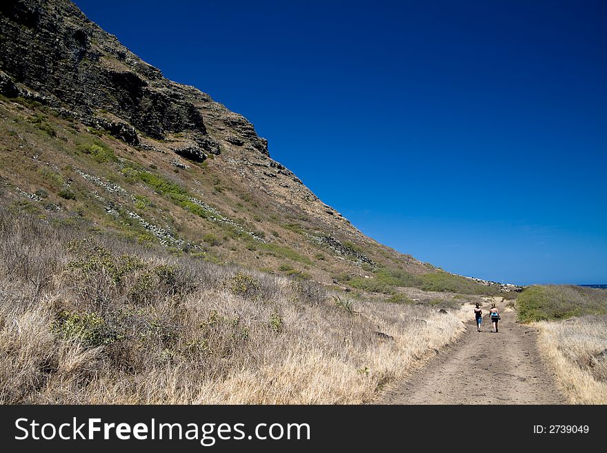 Two girls hiking toward Ka'ena Point