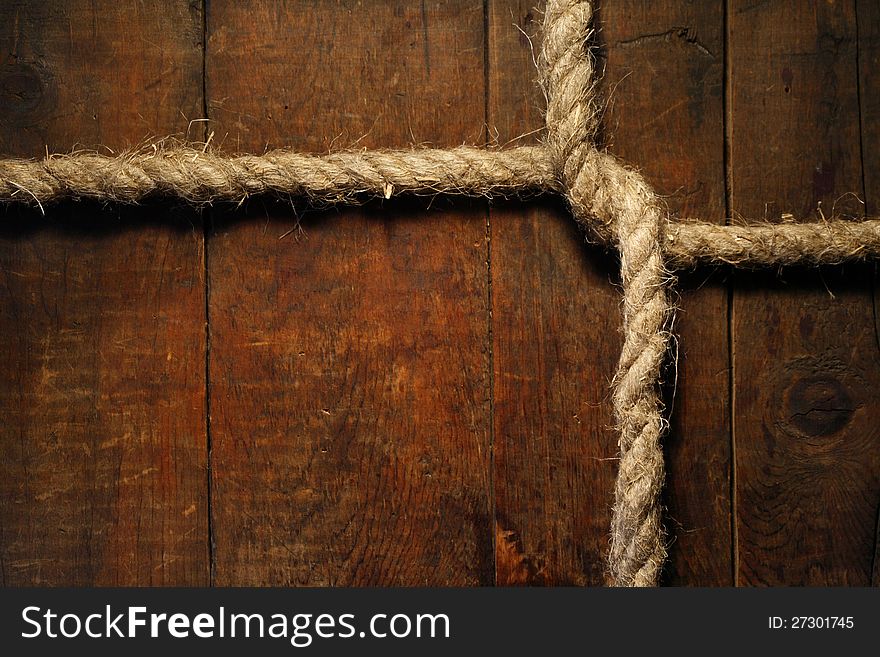 Knotted hemp rope on dark wooden surface. Knotted hemp rope on dark wooden surface