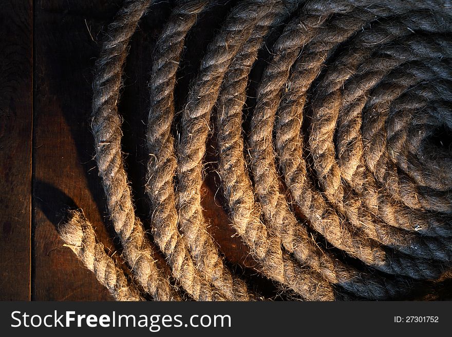 Skein of old hemp rope on dark wooden surface. Skein of old hemp rope on dark wooden surface