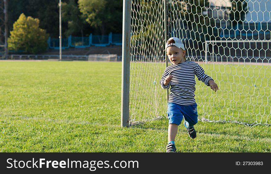 Little boy running on a soccer field