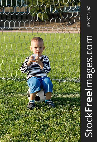 Little boy drinking while playing soccer