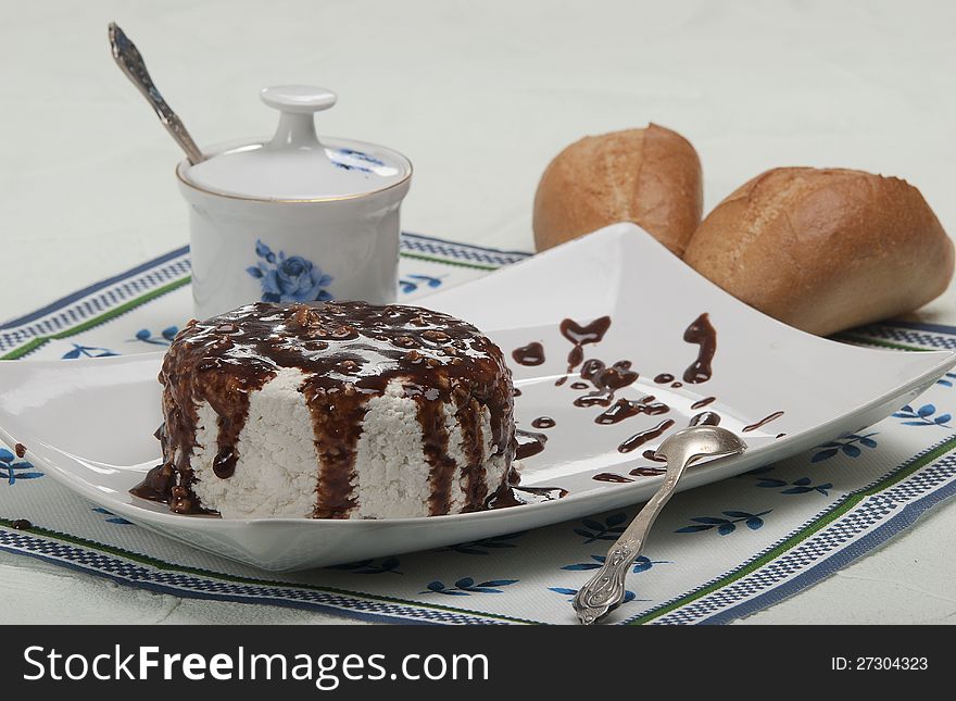 Cottage cheese Poured by chocolate with nutlets, a roll on a napkin