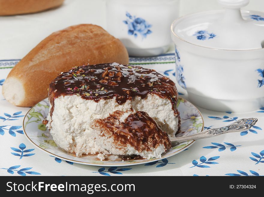 Cottage cheese Poured by chocolate with nutlets, a roll on a napkin