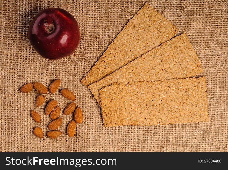 Red apple with crispbread and almonds