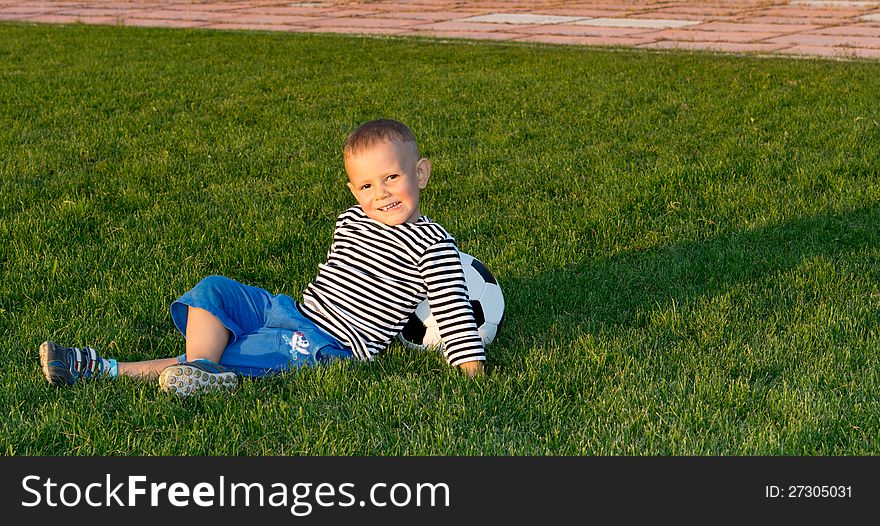 Small boy lying on green grass