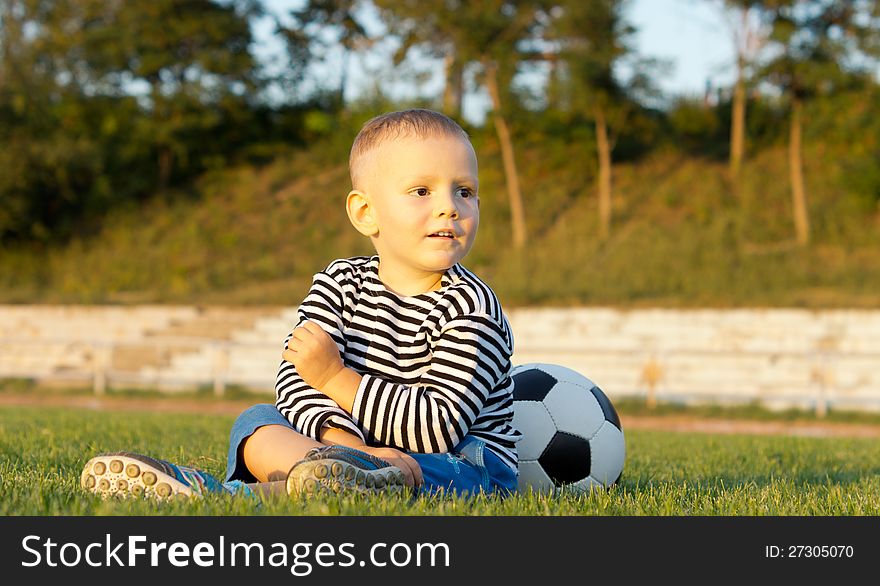 Young boy sitting with his soccer ball