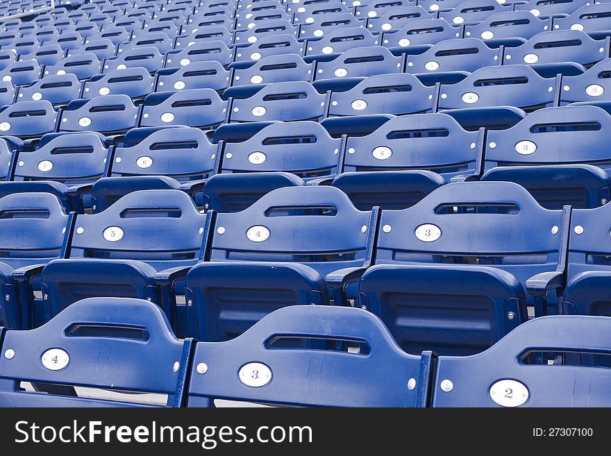 Rows of empty blue numbered stadium or arena seating. Rows of empty blue numbered stadium or arena seating