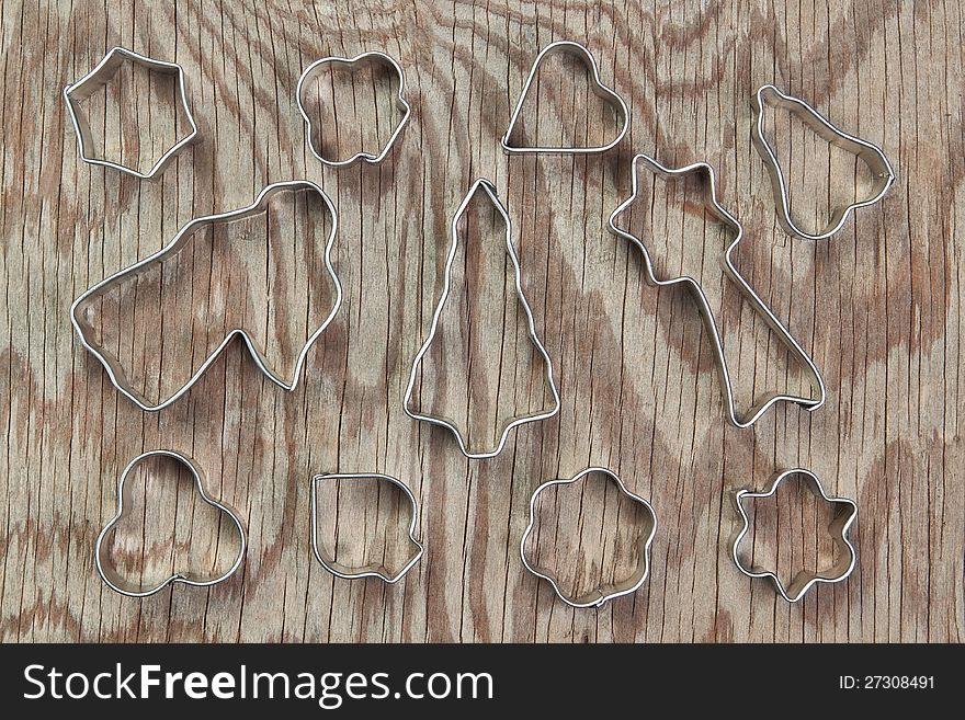 Metal molds for Christmas cookies on a wooden texture. Metal molds for Christmas cookies on a wooden texture.