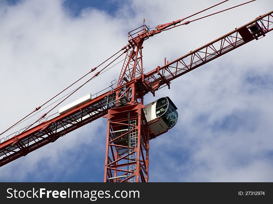 A big construction crane with cloudy sky