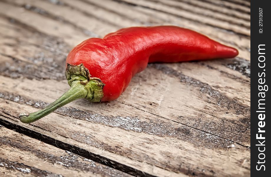 Fresh chili pepper on a old wooden plank