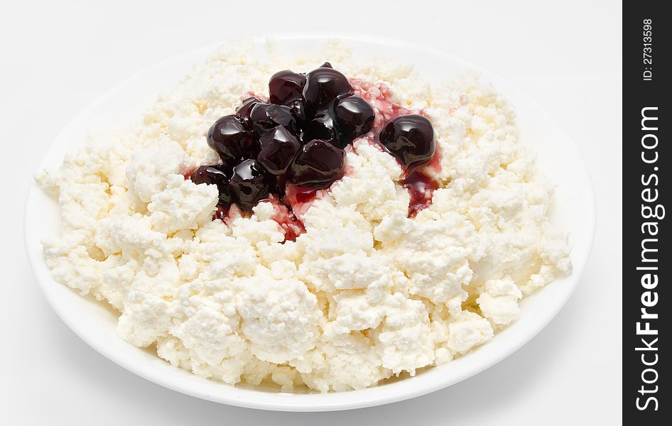 Fresh cottage cheese in the bowl with cherry jam  on a white. Fresh cottage cheese in the bowl with cherry jam  on a white