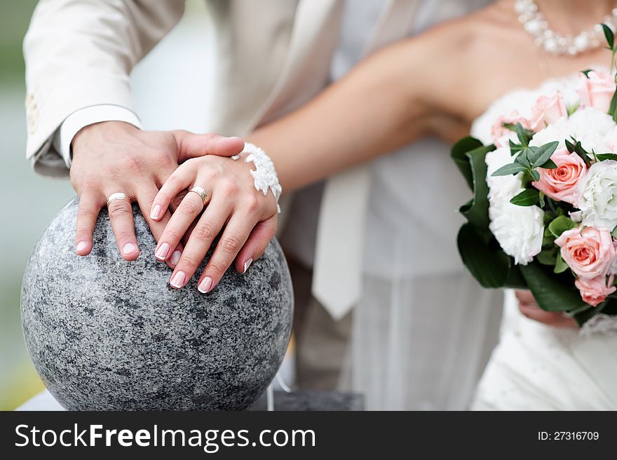 Bride and groom with flowers and wedding rings close-up