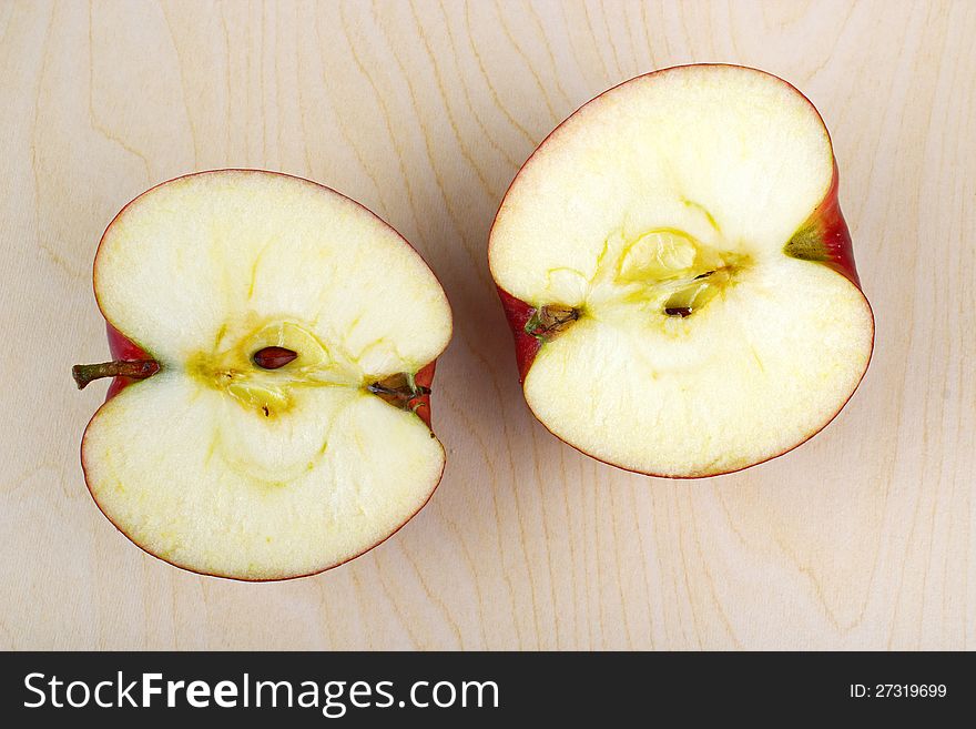 Halved apple in wooden table