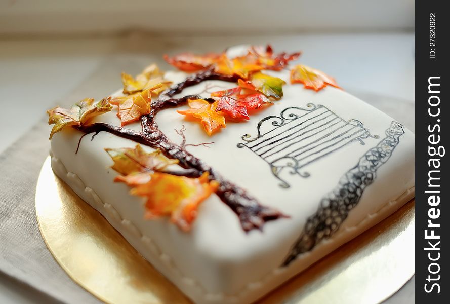 Delicious cake on white painted branch with autumn leaves and a bench. Delicious cake on white painted branch with autumn leaves and a bench