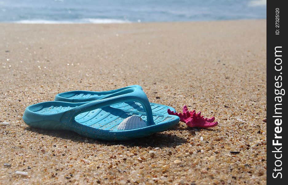 Flip-flops and pink starfish on the beach