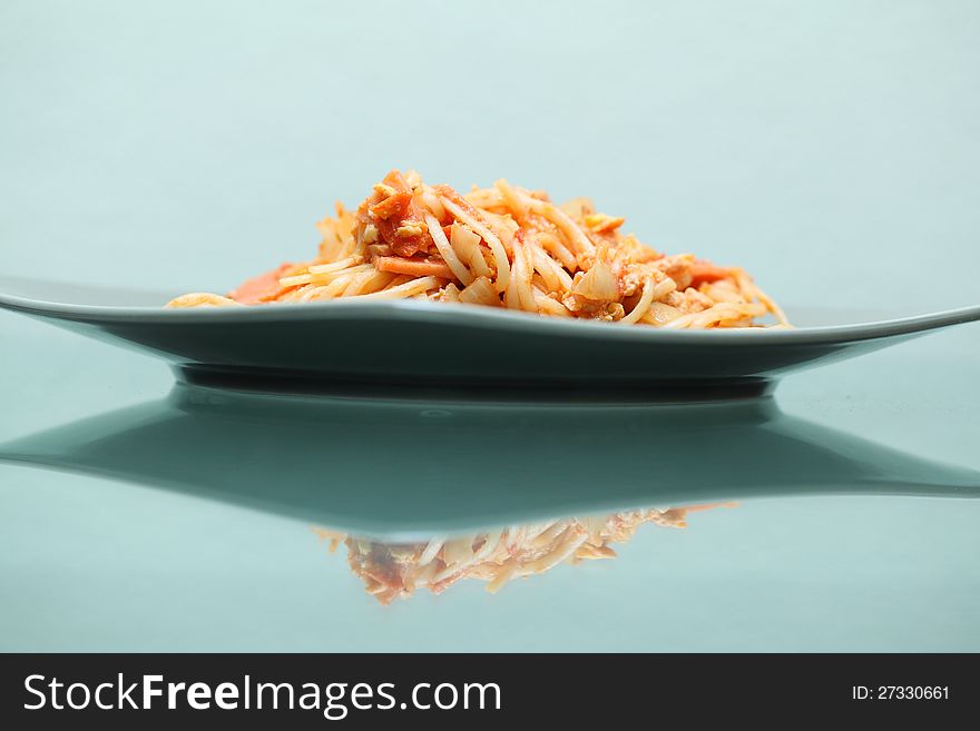 Spaghetti on dish on green glass table