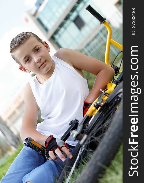 Pretty boy with his bicycle outside in the afternoon