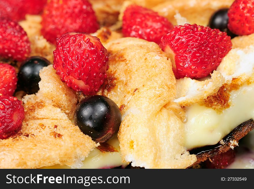 A close-up of delicious homemade custard and meringue cake with strawberries and blackcurrant. A close-up of delicious homemade custard and meringue cake with strawberries and blackcurrant