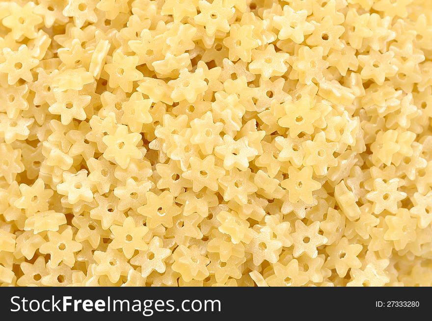 A close-up of star-shaped stelle pasta as a background. A close-up of star-shaped stelle pasta as a background