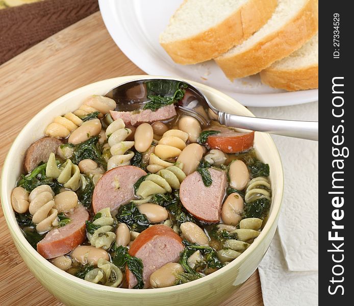 Bowl of soup with sausage, spinach, noodles and beans. Bowl of soup with sausage, spinach, noodles and beans