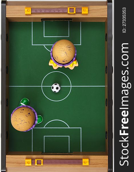 Two eggs playing soccer on soccer table, viewed from above.