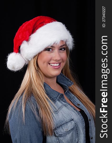 A portrait of a smiling, blond, Christmas Santa girl with red hat