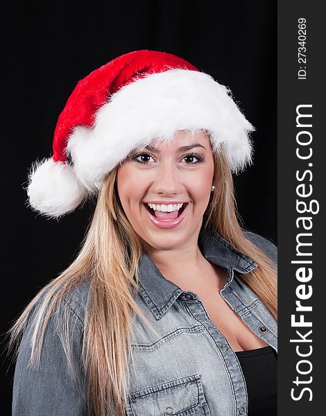 A portrait of a smiling, blond, Christmas Santa girl with red hat