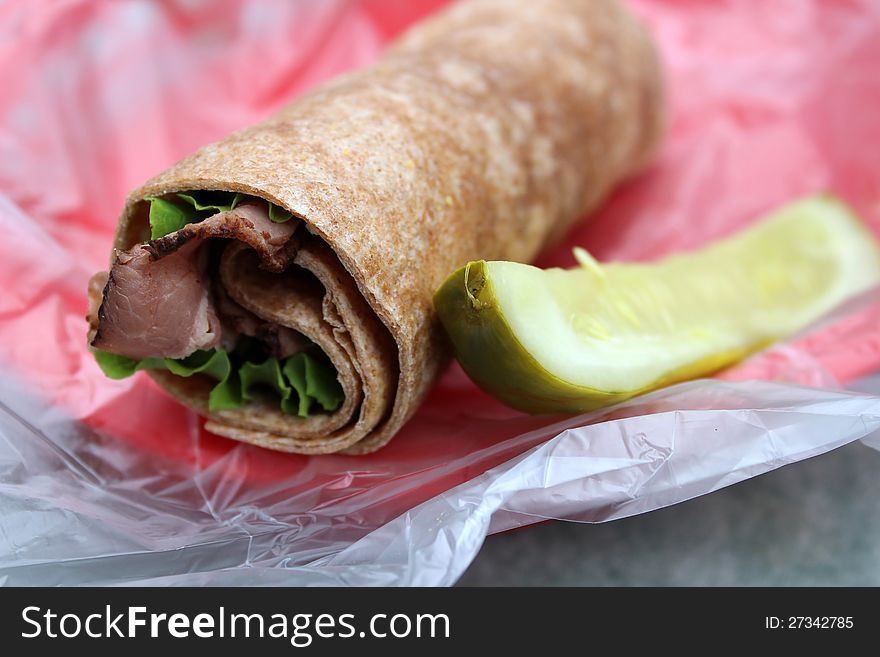 Tasty roastbeef and horseradish sauce in whole wheat wrap with lettuce and dill pickle on the side makes a healthy lunch. Tasty roastbeef and horseradish sauce in whole wheat wrap with lettuce and dill pickle on the side makes a healthy lunch.