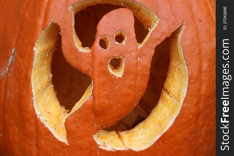 Ghost cut-outs on a bright and colorful jack-o-lantern, set outside to scare passerbys. Ghost cut-outs on a bright and colorful jack-o-lantern, set outside to scare passerbys.