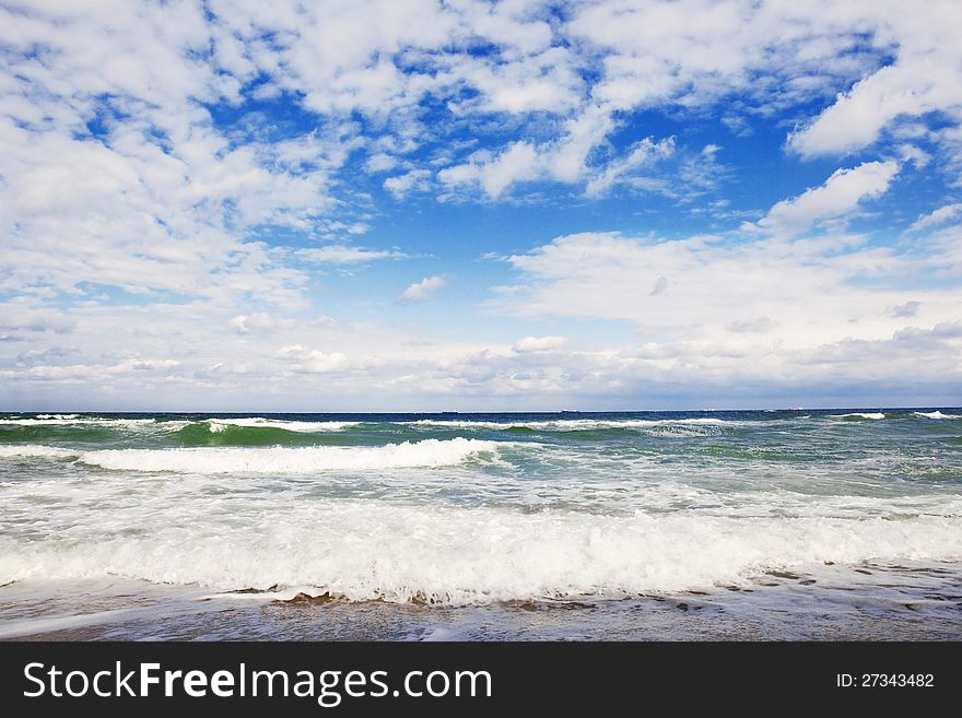 Green stormy sea and cloudy sky