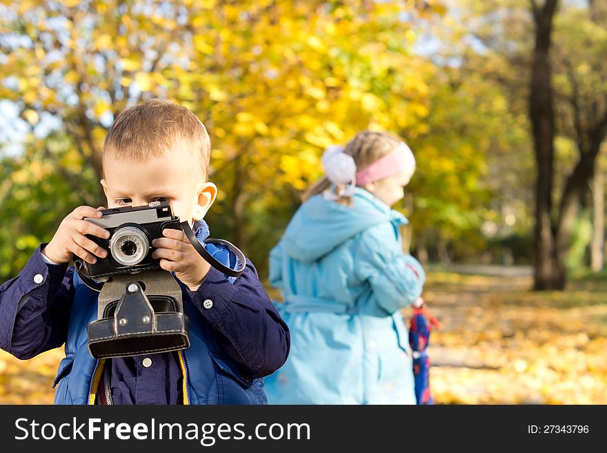 Little Boy Playing With A Retro Camera