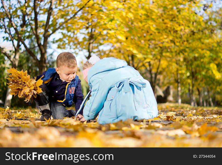 Brother And Sister Playing In Fall Leaves