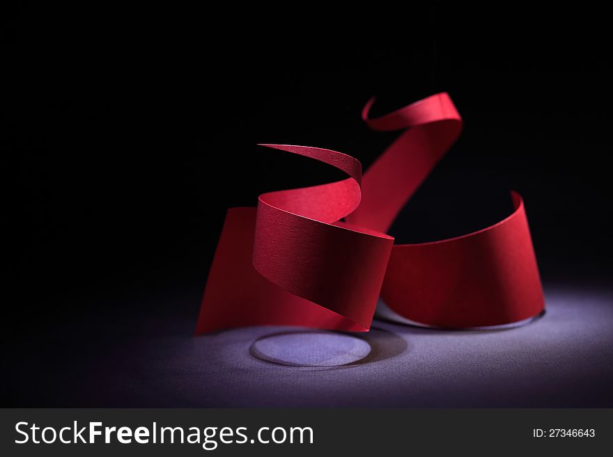 Abstract composition with red paper spiral on dark background. Abstract composition with red paper spiral on dark background